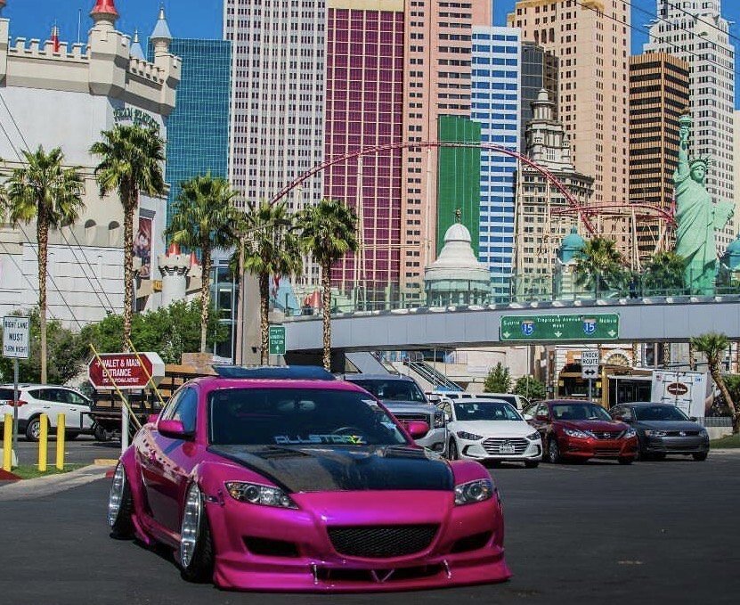 Candy pink Mazda RX-8 with a carbon hood and widebody kit parked on the Las Vegas strip